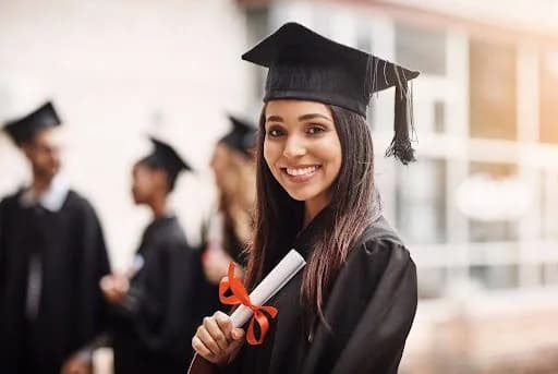 a student holding a school diploma at graduation
