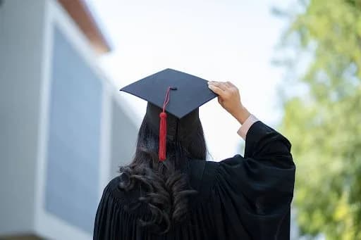 a girl with black hair is wearing a graduation cap