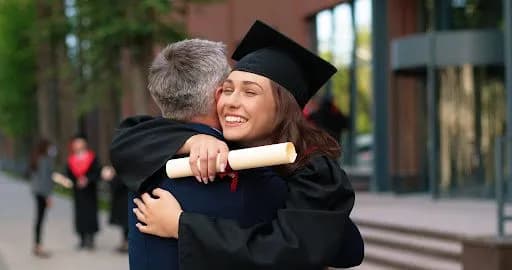 a happy graduate hugging a family member