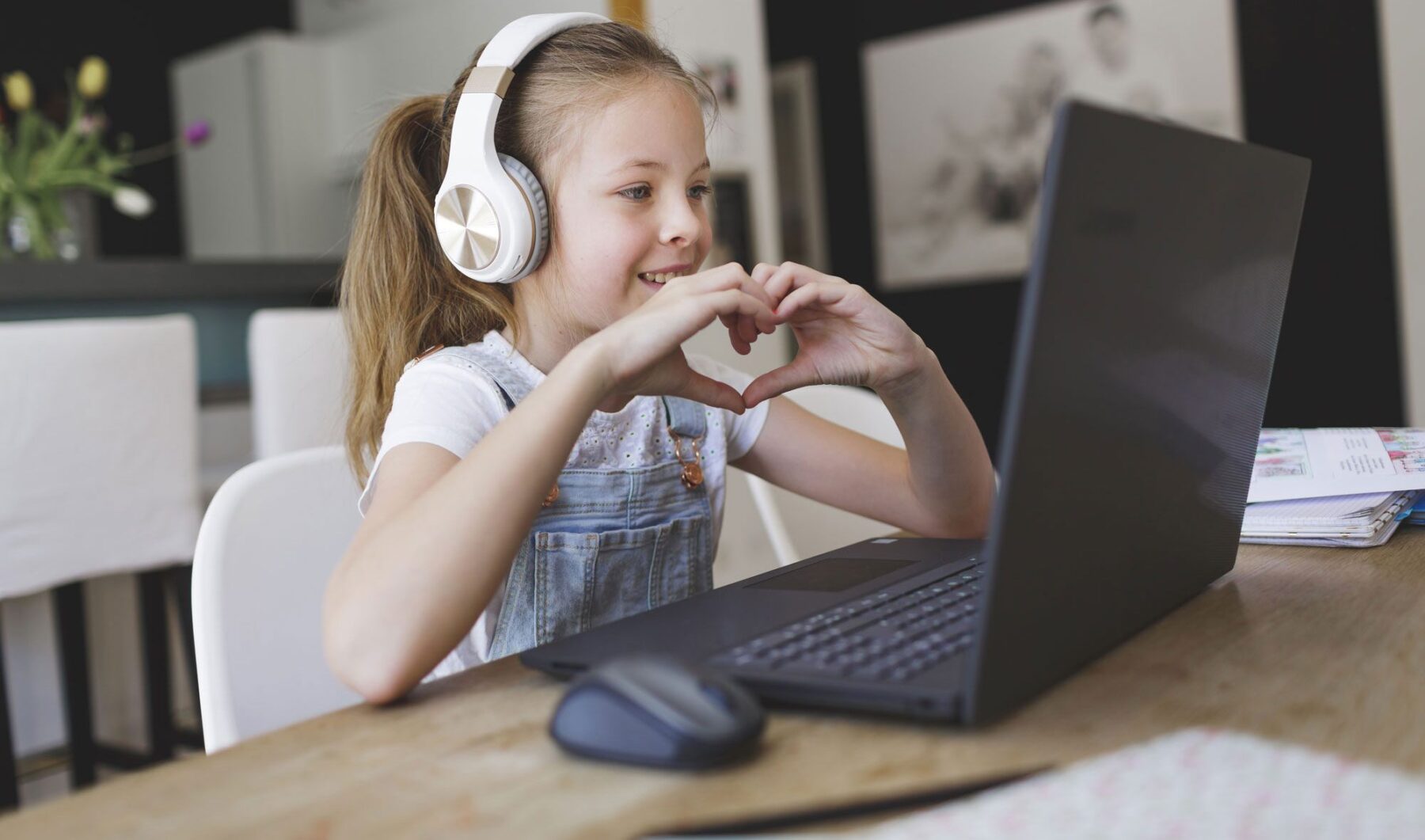 young girl wearing headset attending online classes.